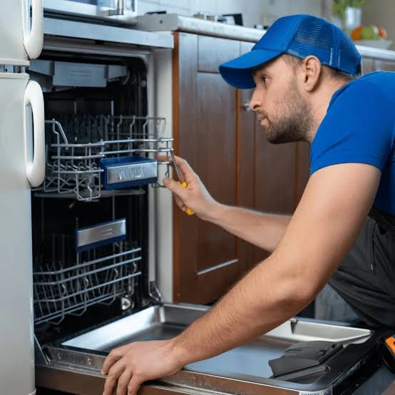 Technician inspecting an open dishwasher and its racks